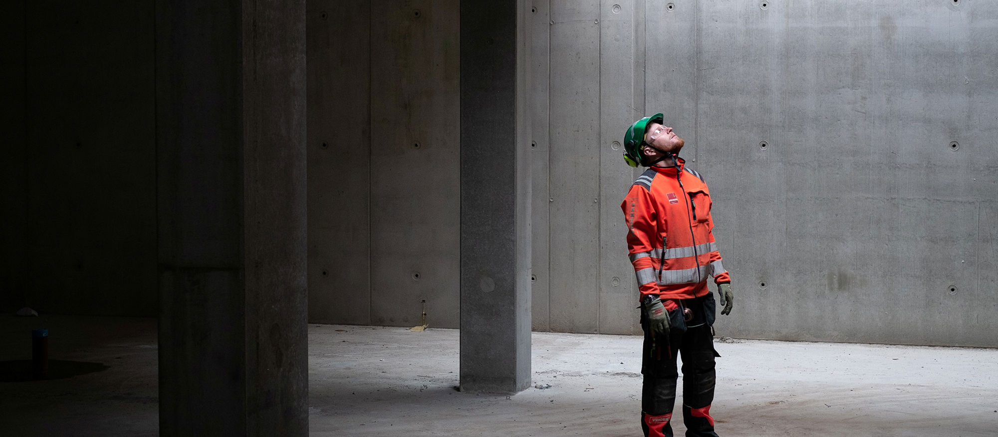 Mann i bygg med betongvegger. Foto.